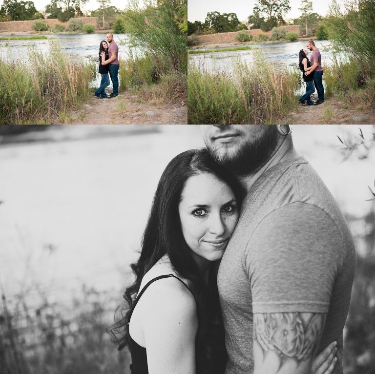 Long brown haired woman, tall tattooed man, standing by american river taking engagement photos