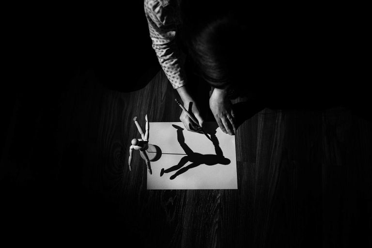 Child tracing a shadow on paper in black and white