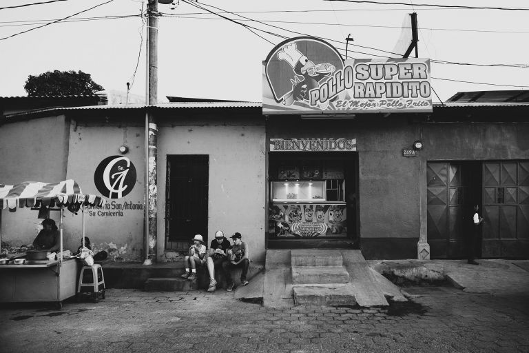 kids eating fried chicken on a curb in guatemala