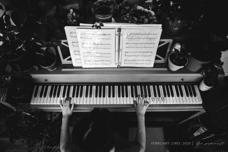 hands playing piano in black and white